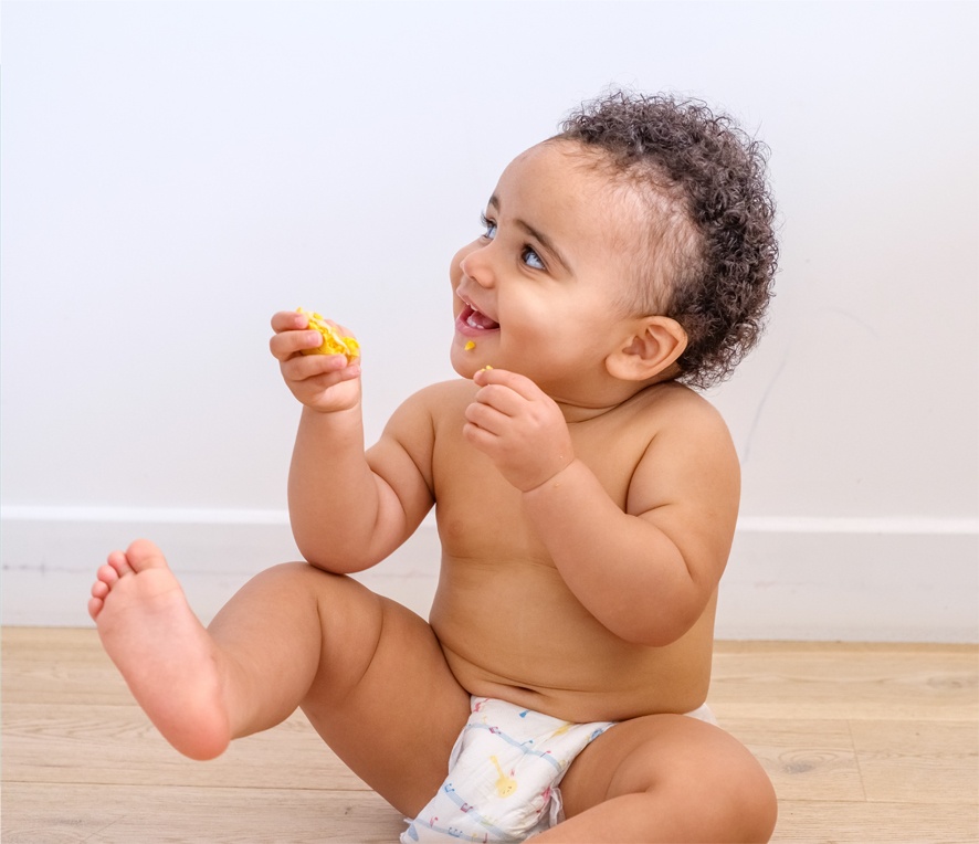 Photo d'un bébé portant une couche écologique qui mange
