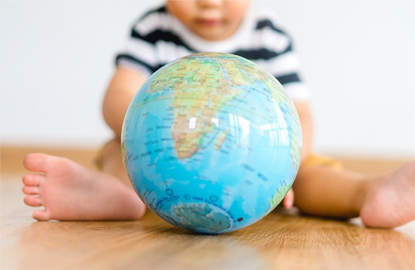 Photo d'un bébé qui joue avec un globe